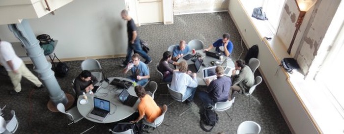 Сильно увеличенная и неинформативная фотография каких-то мальчиков с ноутбуками в обшарпанном зале